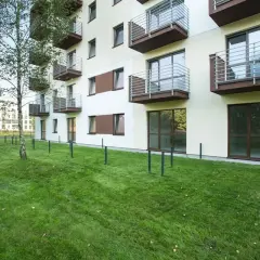 Nowa ustawa o spółdzielniach mieszkaniowych wchodzi w życie. Nowoczesny blok z balkonami i zielonym trawnikiem.