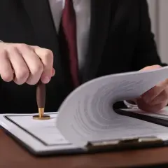 Prawnik pieczętuje dokumenty, ustalając ile wynosi podatek od spadku mieszkania.
