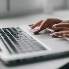 Dłonie z różowym lakierem na paznokciach pracują na touchpadzie laptopa. To efekt pracy nad projektem, który wymaga precyzji, jak druk sd-3.