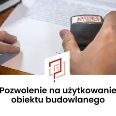 Ręka z pieczątką "APPROVED" nad dokumentem. Oznacza to uzyskanie pozwolenia na użytkowanie obiektu budowlanego.