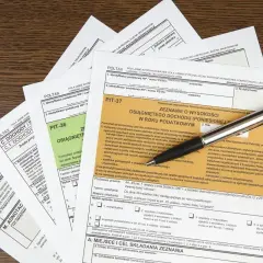 Formularze podatkowe PIT-37 i PIT-36, długopis. Zeznanie o wysokości osiągniętego dochodu, podatek od sprzedaży nieruchomości.