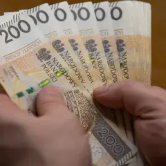 Dłonie trzymają stos banknotów po 200 zł. To hojna darowizna w pierwszej linii, która pomoże potrzebującym.