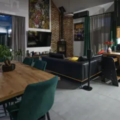 Nowoczesny salon z jadalnią i aneksem kuchennym. Stylowe wykończenie domu, gdzie koszty idą w parze z designem.