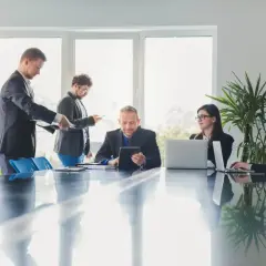 Zespół dyskutuje o tym, jak odwołać prezesa spółdzielni mieszkaniowej. Spotkanie w sali konferencyjnej.