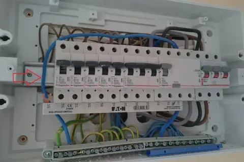 Wnętrze rozdzielnicy elektrycznej z widocznym zabezpieczeniem przedlicznikowym, wyłącznikami i przewodami.