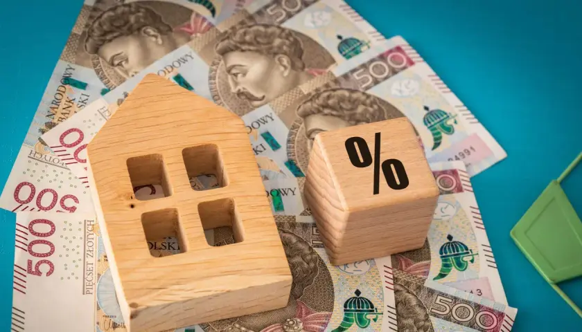 Drewniany domek i kostka z procentem na banknotach 500 zł. Wibor 3m prognozy.