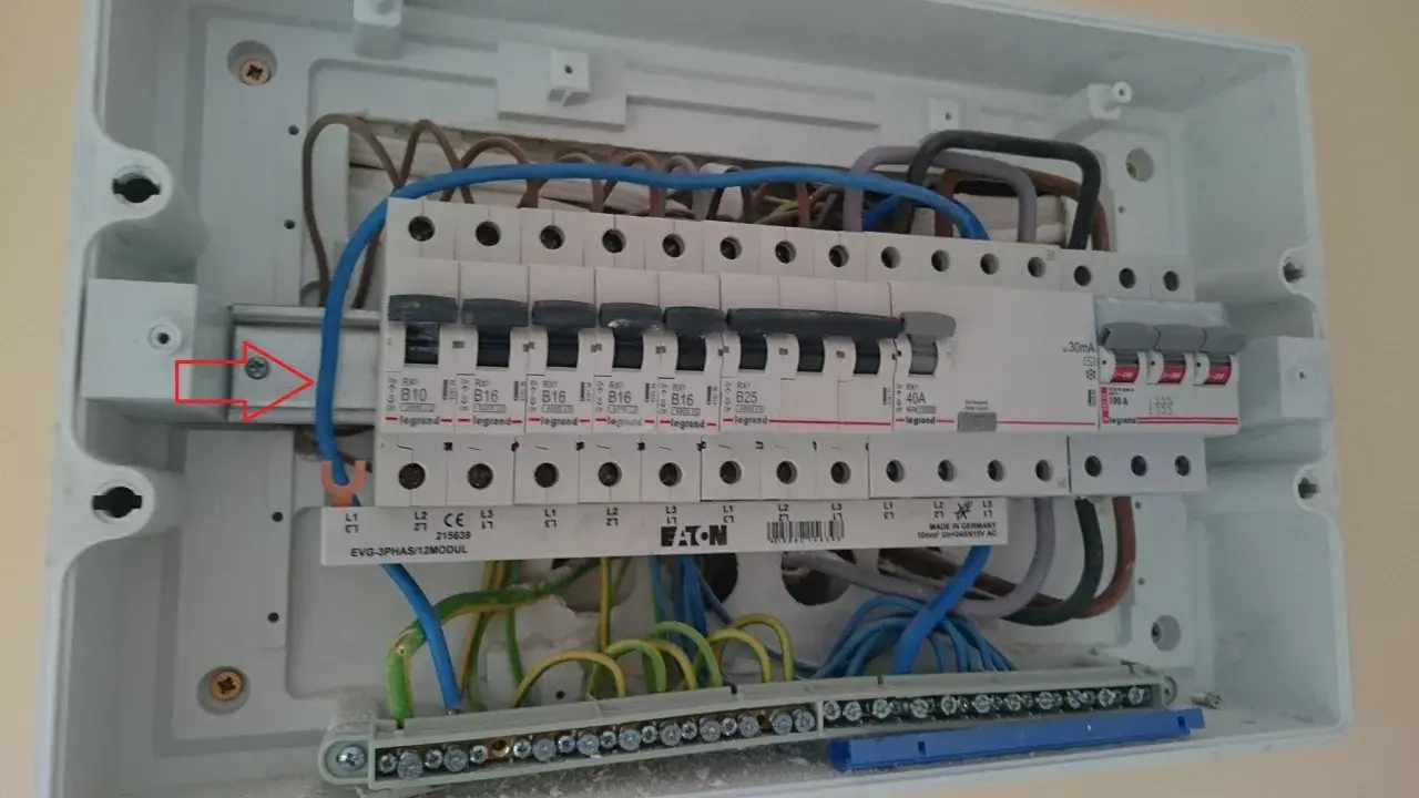 Wnętrze rozdzielnicy elektrycznej z widocznym zabezpieczeniem przedlicznikowym, wyłącznikami i przewodami.