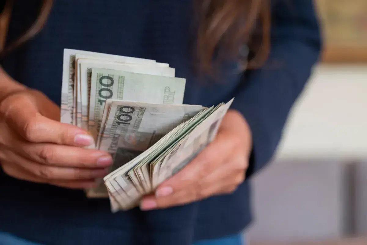 Ręce liczą banknoty 100 zł. To miła darowizna od siostry na nowy projekt.