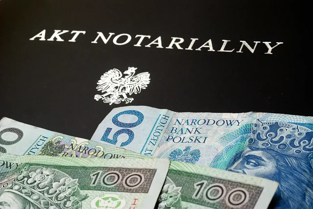 Akt notarialny i polskie banknoty. Dokument potwierdza darowiznę w rodzinie, ułatwiając przekazanie majątku.