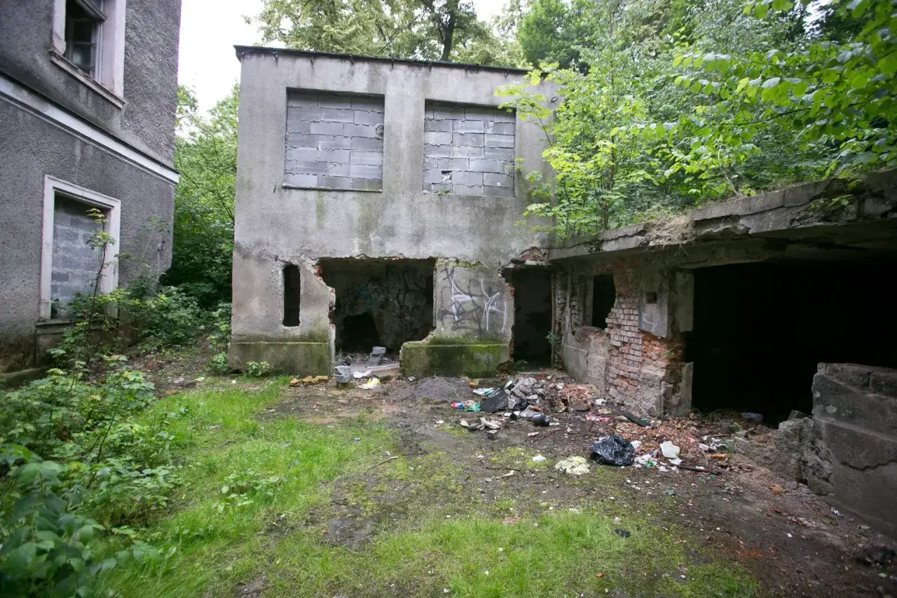 Opuszczony budynek, zniszczony, z gruzem i śmieciami. Widać, ile jest ważne pozwolenie na rozbiórkę, by uniknąć takiego bałaganu.