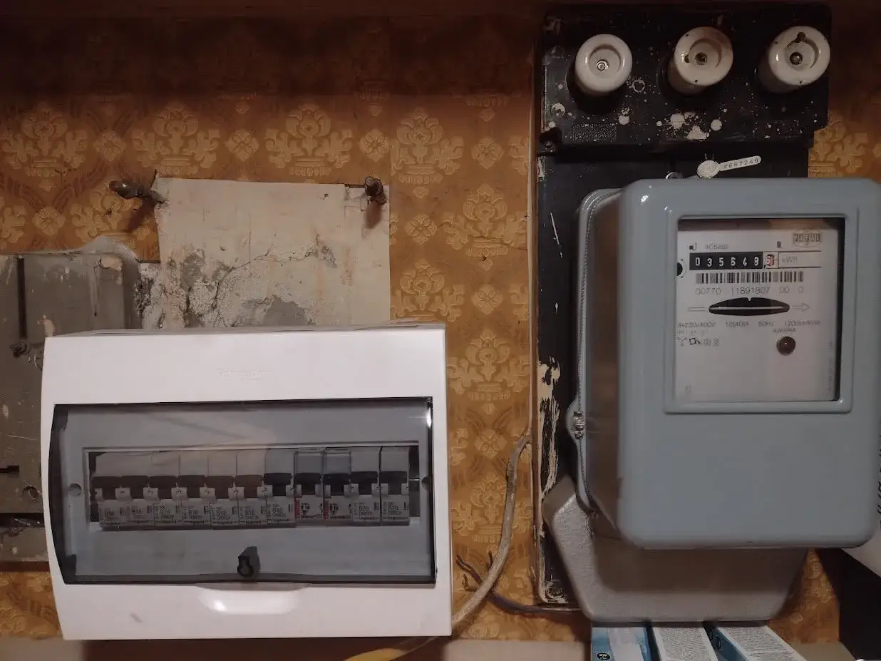 Zabezpieczenie przedlicznikowe i licznik energii elektrycznej. Obok znajduje się tablica z bezpiecznikami.